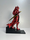 Figurine Igris Solo Leveling en rouge avec une épée, posée sur un socle élégant